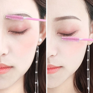 Close-up of pink disposable eyelash spoolies used for combing brows and grafting lashes