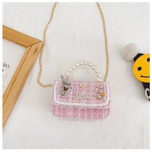 Detail of pink tweed girl's handbag with pearl handle, bunny decor and gold chain strap
