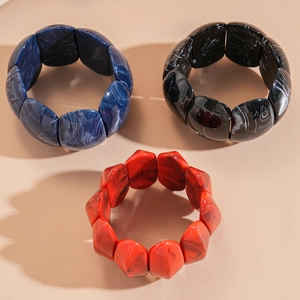 Detailed view of chunky acrylic resin bangles with marble texture in blue, black, and red