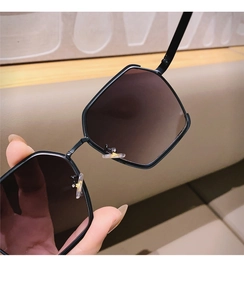 Detail view of semi-rimless geometric sunglasses with slim black metal frame and soft nose pads