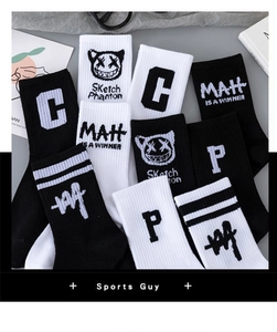 Detail of black and white athletic crew socks featuring trendy letter and graphic prints