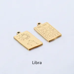 Detail of two gold-plated Libra pendants featuring celestial sun and zodiac engravings