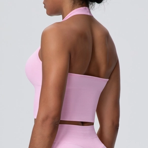 Detail of pink halter yoga bra showing seamless vertical ribbed texture and elastic hem