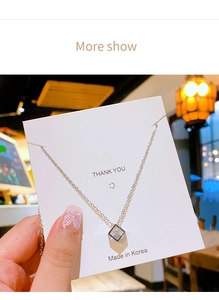 Macro shot of cubic zirconia square pendant necklace with aurora glow on branding card
