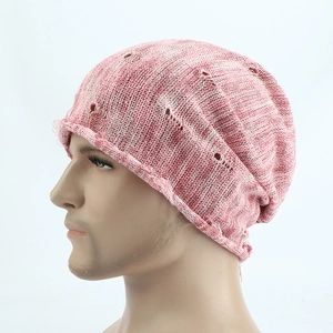 Close-up of pink knit beanie featuring vintage distressed holes and speckled texture