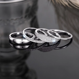 Macro shot of silver stackable rings set with cubic zirconia on reflective surface