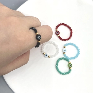Elastic beaded evil eye rings in black, red, white, and green with gold accents