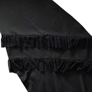 Close-up of black dress featuring tiered ruffle edges and delicate mesh fabric stitching