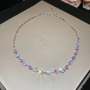 Detailed close-up of sparkling pink and blue round zircon necklace with silver chain