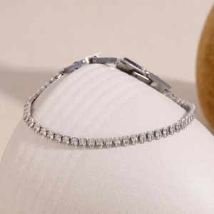 Vue macro du bracelet en argent avec zircons marquise sur un support minimaliste blanc