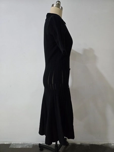 Détail de la robe polo noire en maille montrant la taille côtelée et l'ourlet plissé