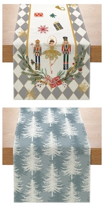 Detail of Christmas table runners with nutcracker and white tree patterns on woven fabric