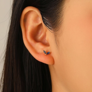 Detailed view of marquise-cut deep blue gemstones set in a gold V-shaped hoop earring