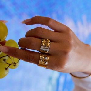Detailed shot of two-tone gold and silver ring with cherry relief on model's hand