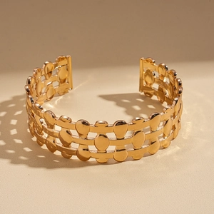Detailed view of triple-layered hollow oval metal cuff bracelet with geometric shadows