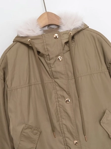 Dettaglio del parka kaki con cappuccio in finta pelliccia bianca e bottoni dorati