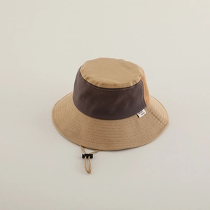Detail of color-block kid's bucket hat featuring adjustable windproof cord and side logo