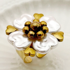 Macro shot of gold floral ring with white baroque pearl petals and heart-shaped center detail