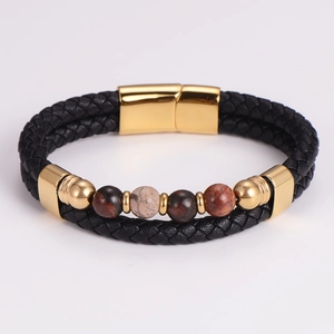 Close-up of black braided leather bracelet with golden clasp and natural stone beads