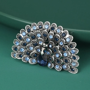 Macro view of peacock brooch with blue crystals and vintage silver metal texture