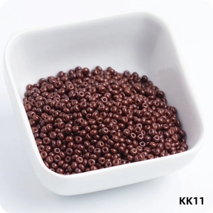 Macro view of 3mm brown wear-resistant glass seed beads in a white ceramic bowl