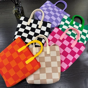 Flat lay of colorful checkered knit tote bags in purple green black pink and orange