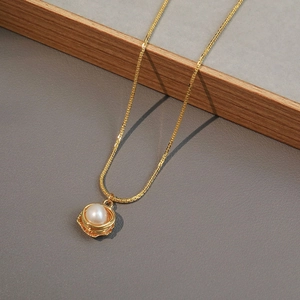 Elegant gold flower pendant necklace with a fresh water pearl in a minimalist wire design