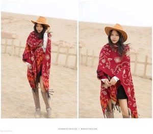 Detail of red ethnic style thick cashmere shawl with floral patterns and black tassels