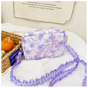 Detail of lavender floral crossbody bag with lace ruffle straps and sequin petals