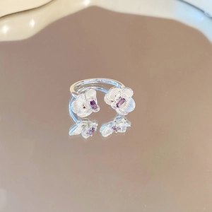 Close-up of silver flower ring with purple zircon stones and detailed petal textures