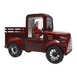 Detail of vintage red tractor water lantern with Santa Claus and swirling glitter snow