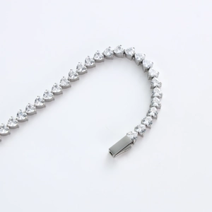 Vista macro del bracciale tennis con zirconi a forma di cuore e chiusura in metallo argento