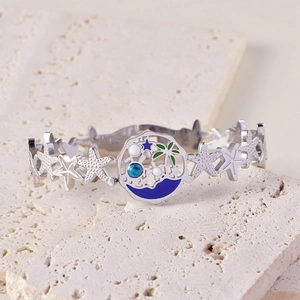 Détail du bracelet étoile de mer argenté avec pendentif rond océan bleu et palmier