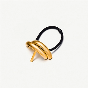 Detail of a minimalist gold double-ring hair tie with black elastic band on white background