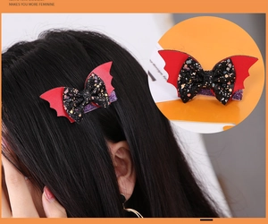 Detail view of a Halloween bat wing hair clip with a black glitter bow for party decor