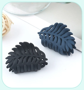 Close-up of leaf-shaped matte shark hair clips in navy blue and black colors