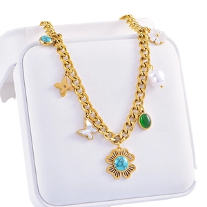 Bohemian gold chain necklace with turquoise, pearl, and white floral charms on a display stand
