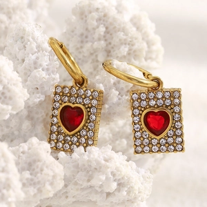 Macro shot of 18K gold plated earring with red heart stone and micro pavé crystals