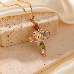 Macro shot of gold cross necklace with multicolored zircons and Virgin Mary medallion