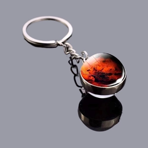 Solar system keychain with double-sided glass orb featuring a red nebula on silver base
