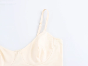 Detail of elegant beige camisole strap and cup structure with smooth textured fabric