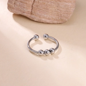 Detailed view of silver anxiety ring with three rotating beads on a minimalist stone