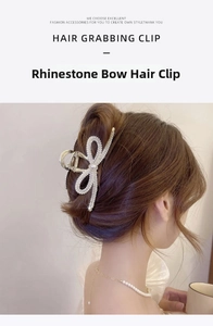 Close-up of golden bow hair claw clip with rhinestones and pearls worn by a model