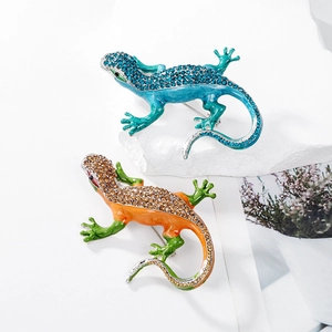 Sparkling crystal lizard brooches in blue and orange enamel set on white stone