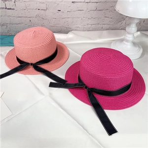 Detail of pink and fuchsia paper straw boater hats with black polka dot bow ribbons