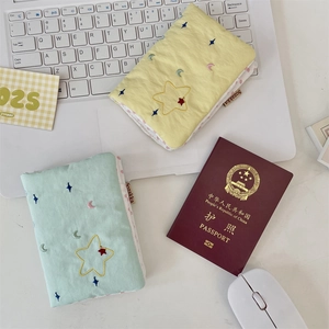 Macro view of quilted fabric passport covers with star embroidery on a laptop