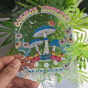 Close-up of holographic mushroom and butterfly suncatcher sticker with Self Love text