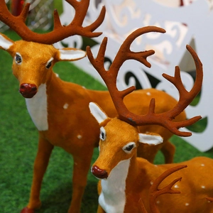 Three orange flocked Christmas reindeer statues in a family set for holiday decor