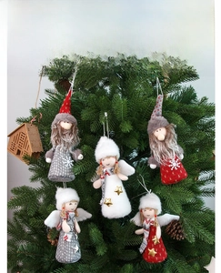 Detailed view of red and grey plush angel and gnome dolls hanging on a Christmas tree