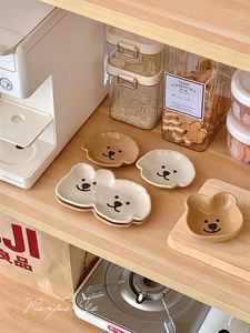 Detail view of cute bear-shaped ceramic dipping sauce dishes in beige and brown colors